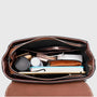 Sac à main en cuir véritable marron avec compartiments et fermeture zippée rempli d’articles personnels