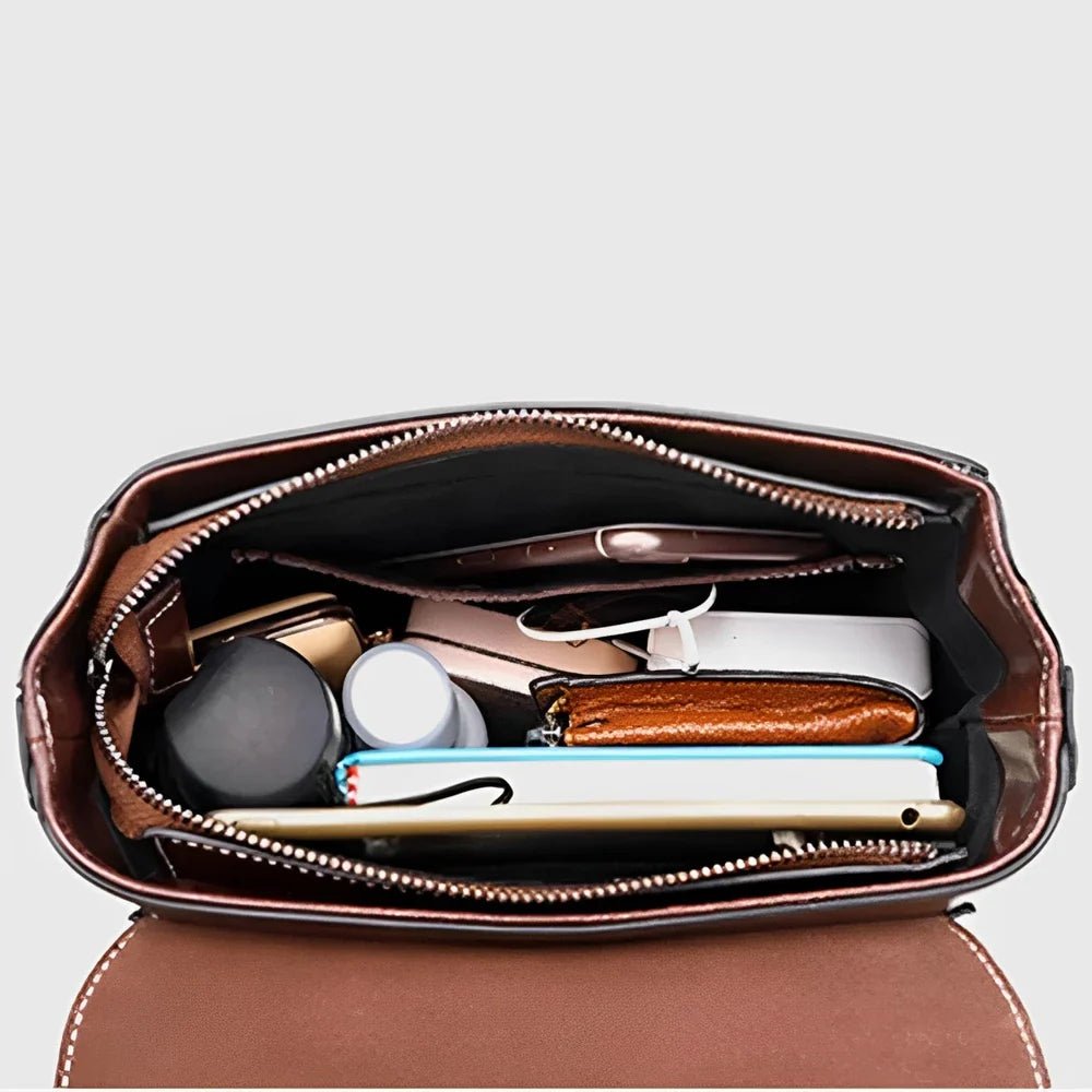 Sac à main en cuir véritable marron avec compartiments et fermeture zippée rempli d’articles personnels