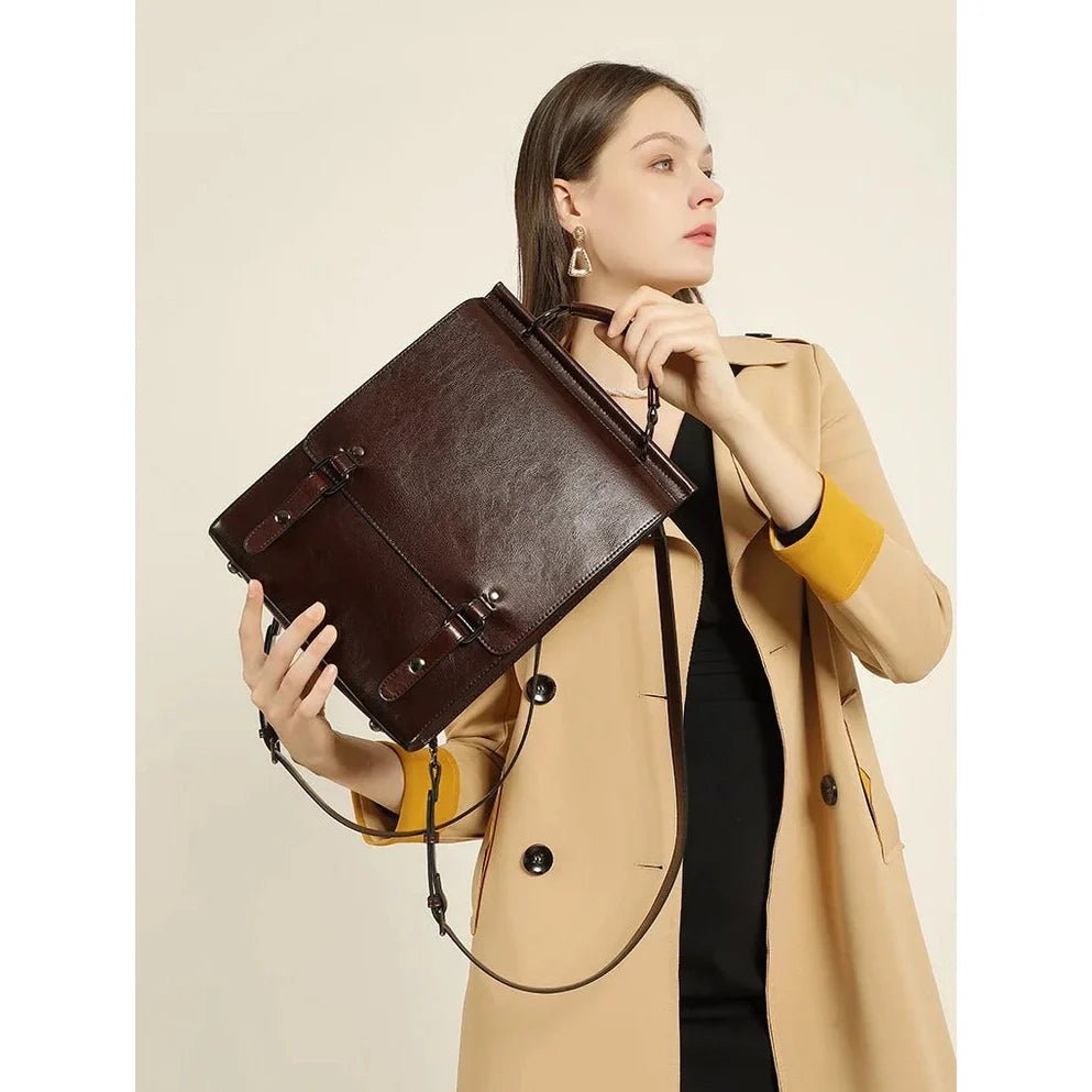 Femme tenant un cartable vintage en cuir marron avec bandoulière et rabat à boucle