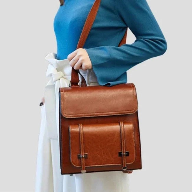 Femme tenant un Petit cartable en cuir marron avec rabat et poches à boucles