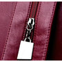 Zoom sur un sac à dos en cuir bordeaux avec fermeture éclair argentée pour femme tendance