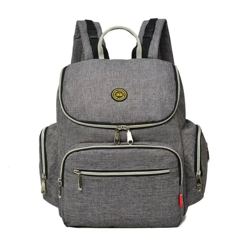 Sac à dos à langer gris avec plusieurs compartiments zippés et poignées supérieures