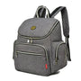 Sac à dos à langer gris en tissu avec plusieurs compartiments zippés et bretelles rayées noir et blanc