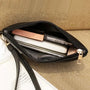 Pochette femme en cuir noire ouverte avec contenu élégante et pratique