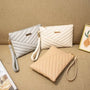 Trois pochettes en cuir matelassé blanc, gris clair et beige pour femme