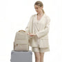 Sac à dos Amber beige avec accents dorés et design structuré élégant