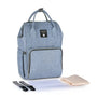 Sac à dos bébé à langer en tissu bleu clair avec plusieurs compartiments et options de port