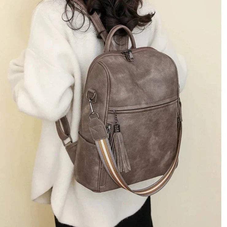 Sac à dos cuir souple gris en faux cuir, bandoulière rayée et charm tassel