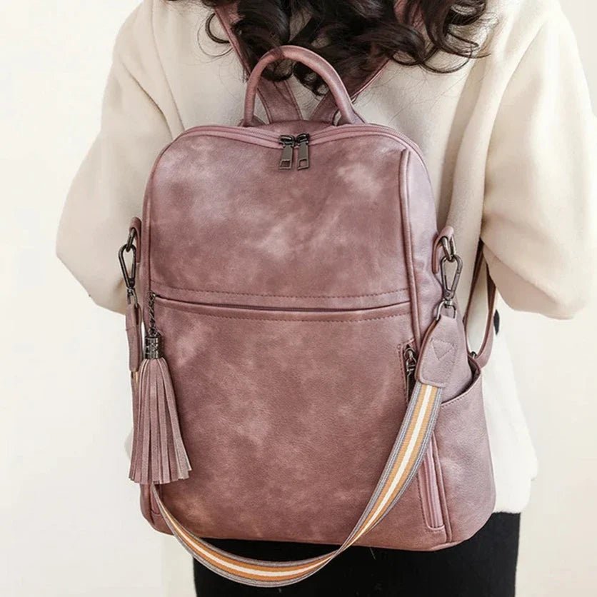 Sac à dos cuir souple en rose poussière avec pompon et bandoulière rayée