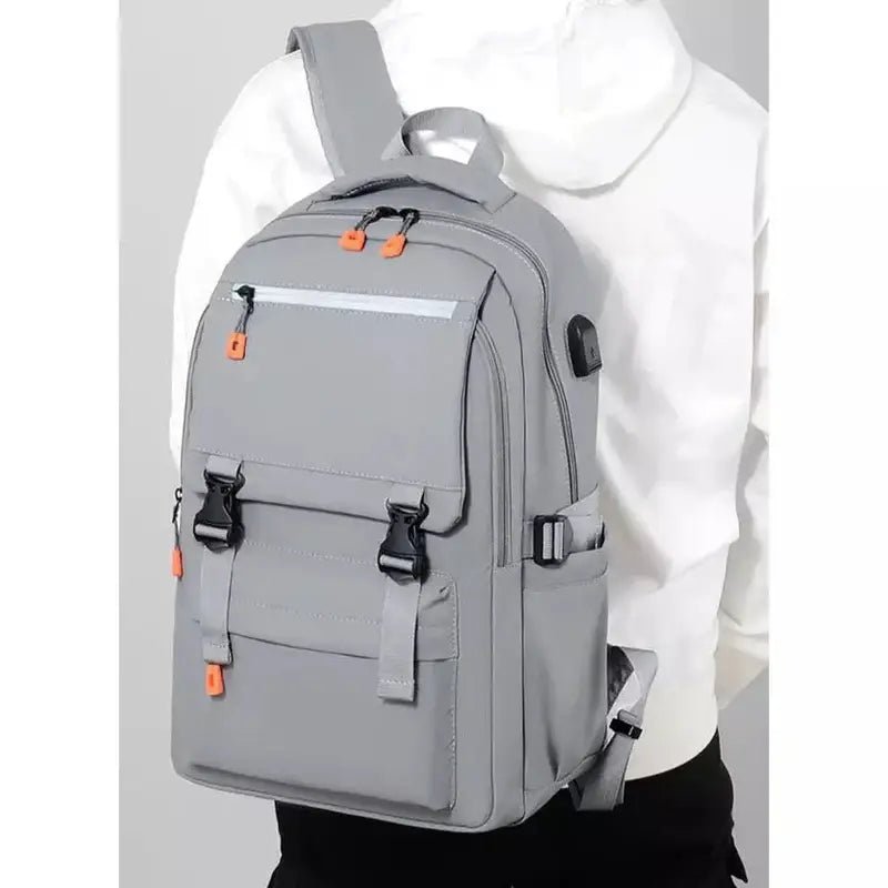 Sac à dos de cours gris avec accents orange, multiples compartiments et port USB