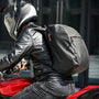 Sac à dos de moto noir porté par un pilote en veste en cuir