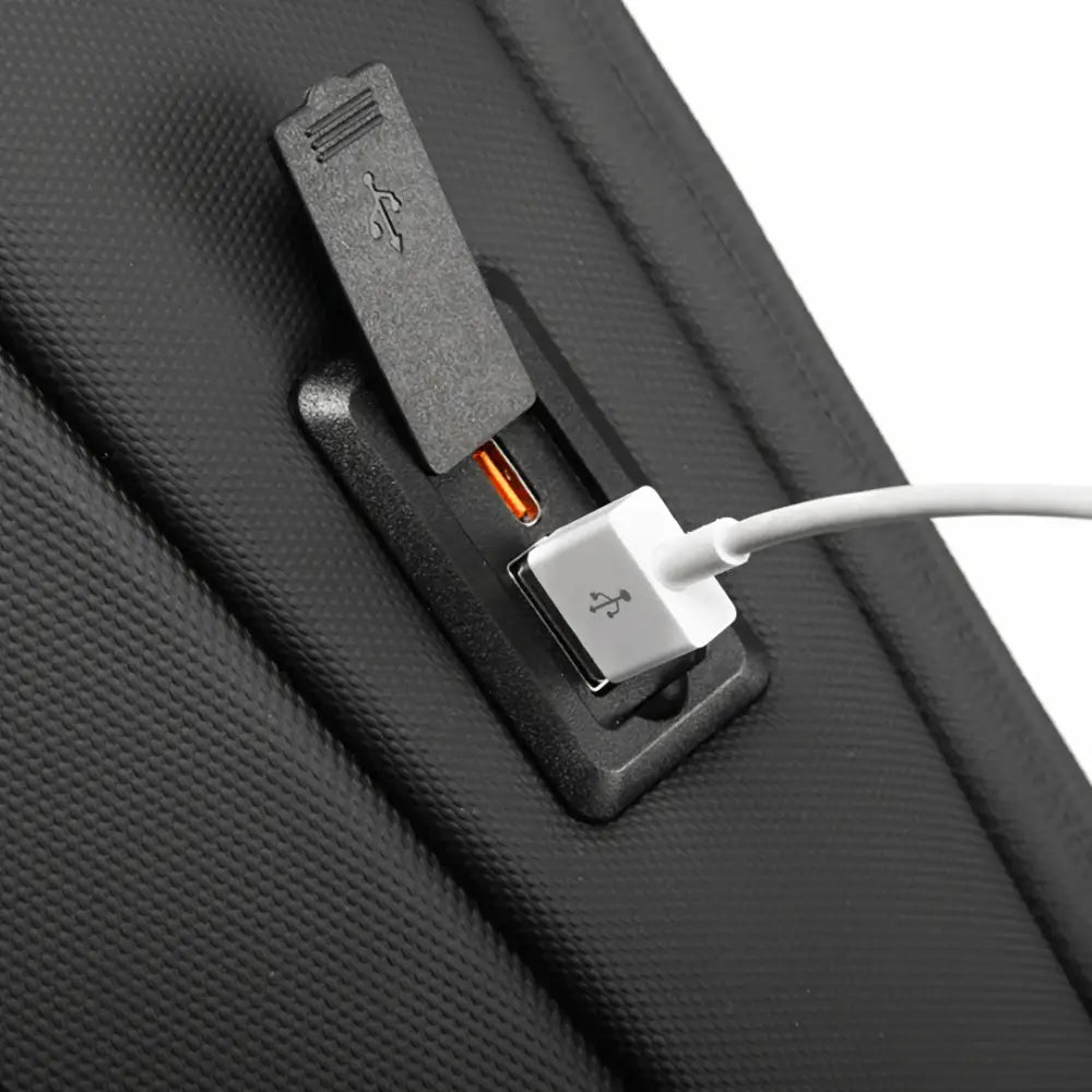 Port de chargement USB externe sur un sac à dos de ville antivol CityGuard noir texturé
