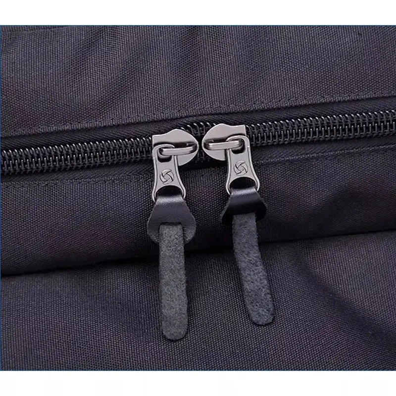 Deux zippers gris foncé avec tirettes assorties sur un sac à dos design noir