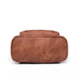 Vue inférieure d’un sac à dos en cuir végétal marron avec zippers visibles