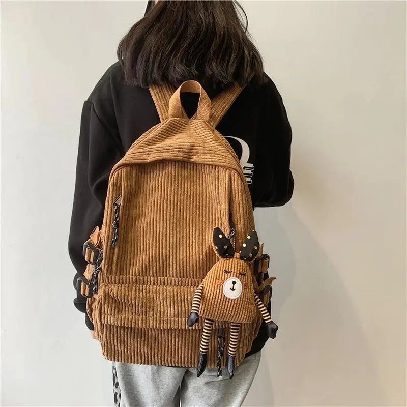 Sac à dos en velours brun avec un petit animal en peluche attaché