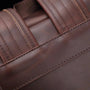 Détail en gros plan du rembourrage en cuir marron avec couture visible pour Sac à dos homme cuir vintage