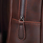 Premier plan d’un sac à dos homme cuir vintage avec fermeture éclair en métal