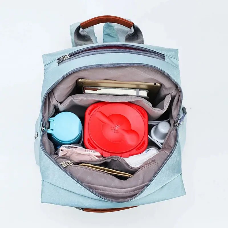 Sac à dos à langer bébé bleu clair avec plusieurs compartiments et poignée marron