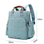 Sac à dos à langer bébé bleu clair matelassé avec poignée en cuir brun et poches latérales