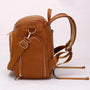 Sac à dos à langer en cuir marron avec multiples poches zippées et bretelles ajustables