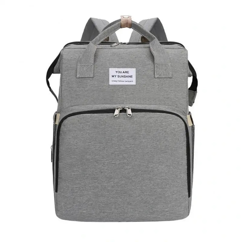 Sac à dos à langer extensible en tissu gris avec plusieurs compartiments et poignées supérieures