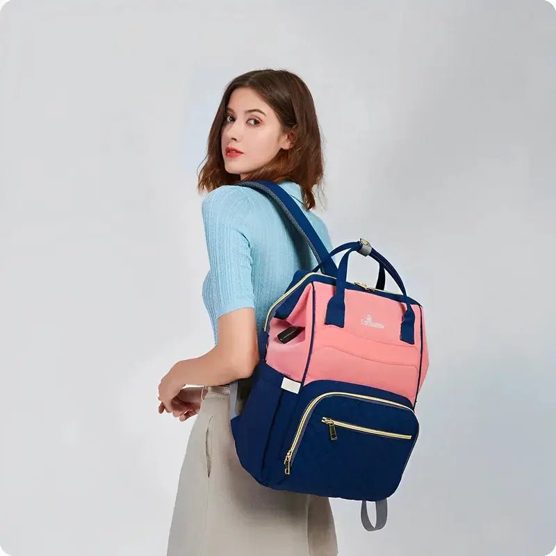 Sac à dos à langer Le Queen rose et bleu marine avec zippers dorés et compartiments