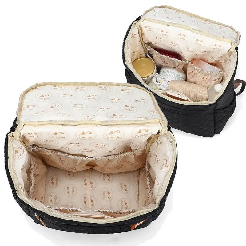 Sac à dos à langer noir avec deux sacs à langer ouverts, un vide et un rempli d’articles pour bébé
