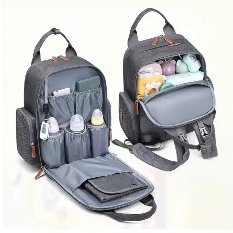 Sac à dos sac à langer gris ouverts avec compartiments et articles pour bébé