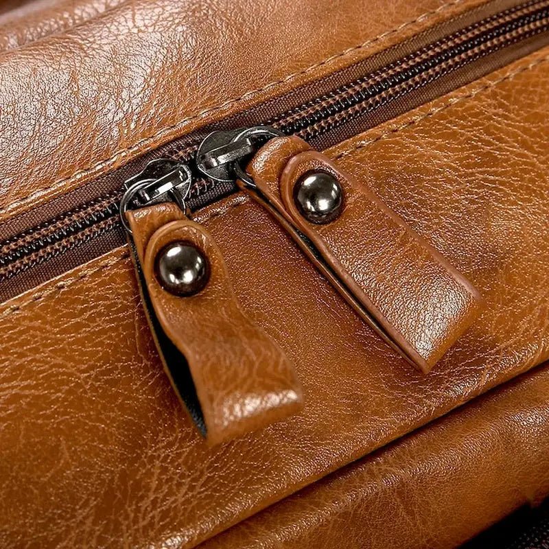 Détail en gros plan d’un sac à dos ordinateur homme en cuir brun avec deux tirettes de fermeture