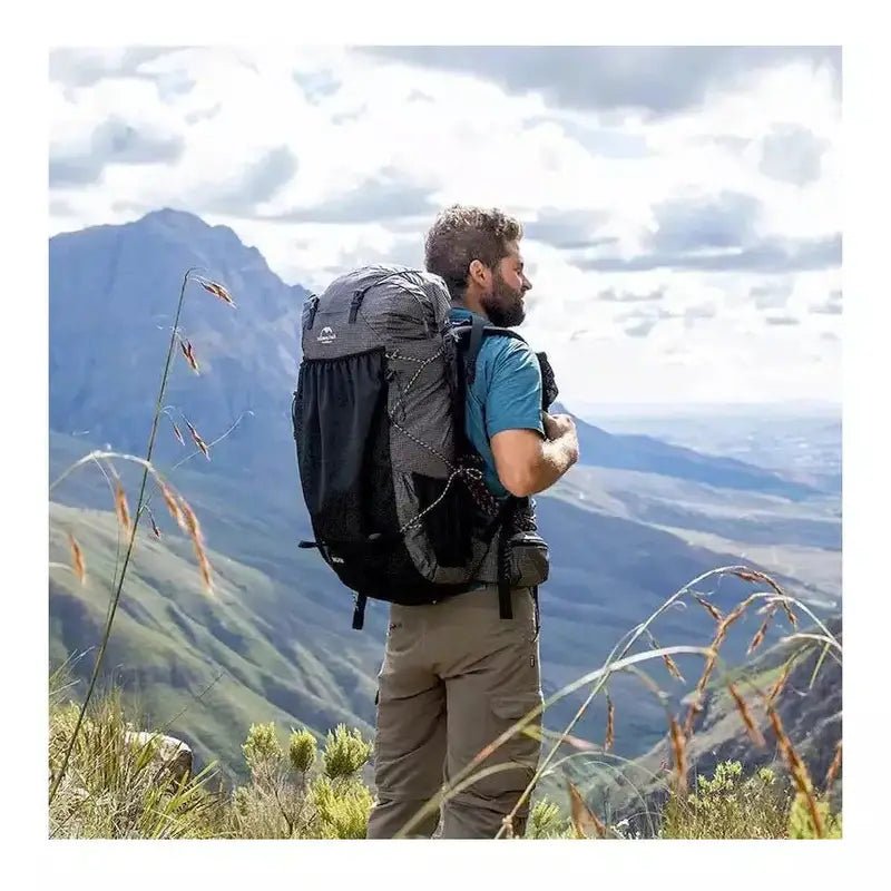 Homme en randonnée avec un sac à dos de 60L gris et noir pour trekking
