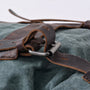 Détail de la boucle en métal sur la sangle en cuir marron foncé du Sac à dos Ruston