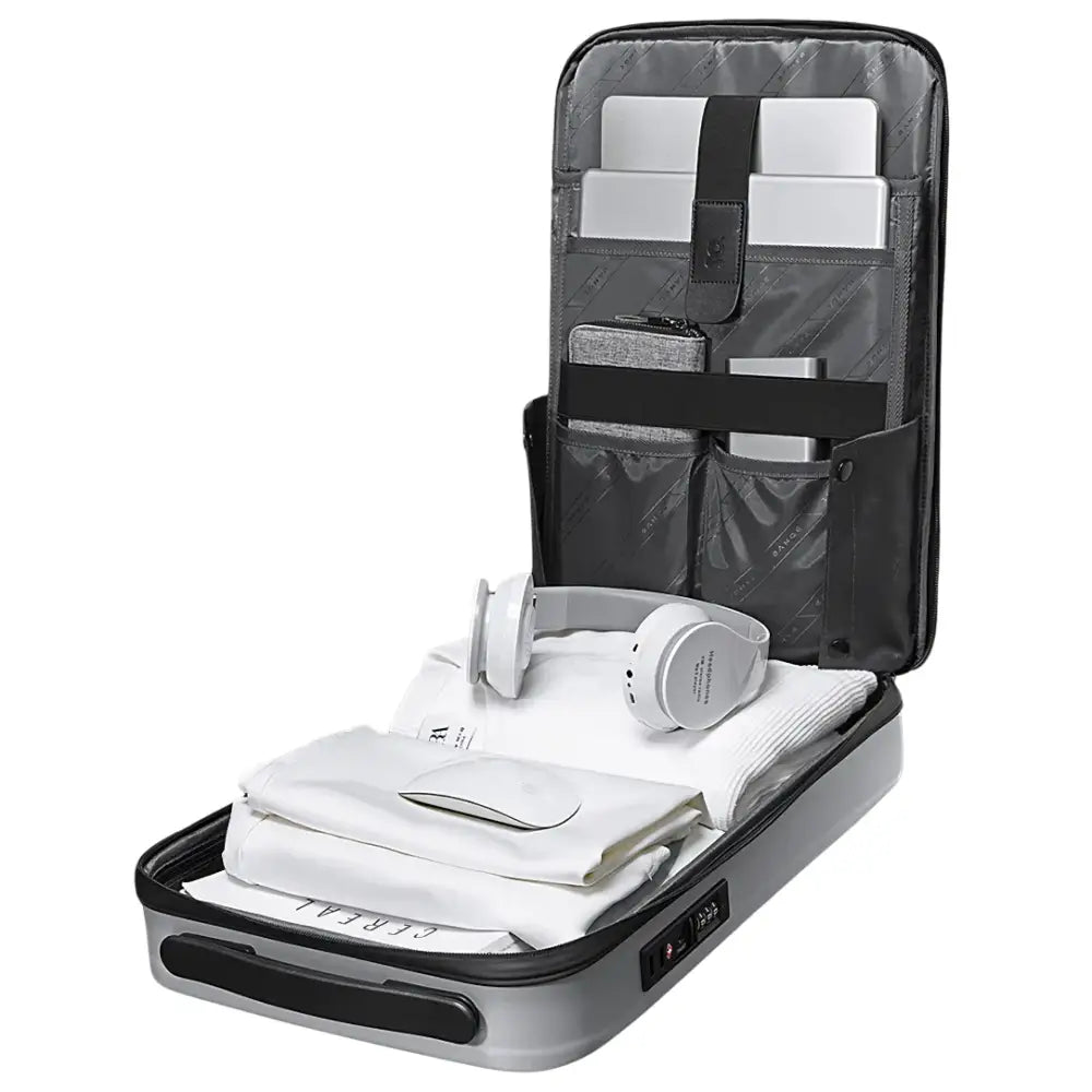 Valise cabine grise ouverte avec compartiments et articles emballés pour Sac à dos Atom