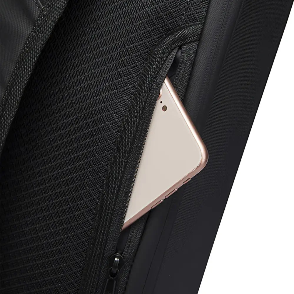 Smartphone partiellement glissé dans la poche latérale du Sac à dos Atom ultraplatforme antivol