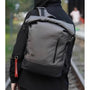 Sac à dos roll top homme gris et noir avec poche verticale et accessoire clé rouge