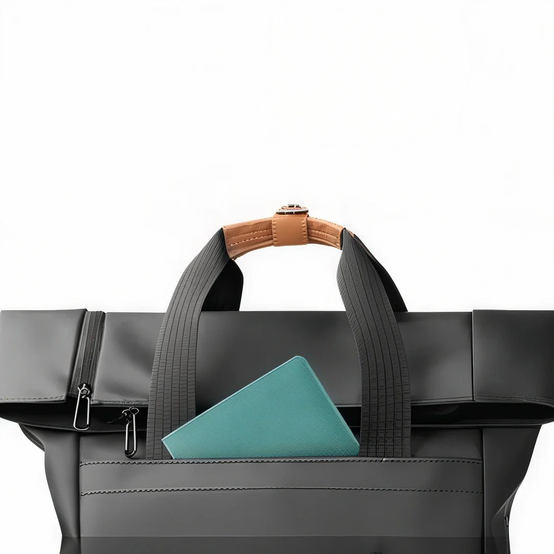 Sac à dos roll top noir avec tote bag noir, carnet teal et poignée en cuir marron