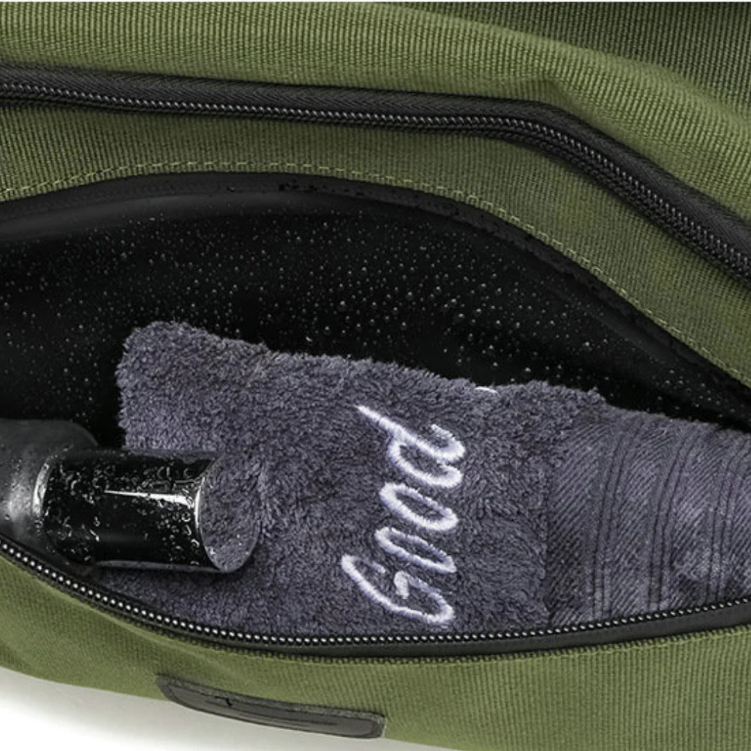 Sac à dos sport 40l olive vert avec poche intérieure humide contenant une bouteille noire et une serviette grise