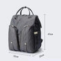 Sac à langer sac à dos gris en tissu avec poches zippées et poignées de transport